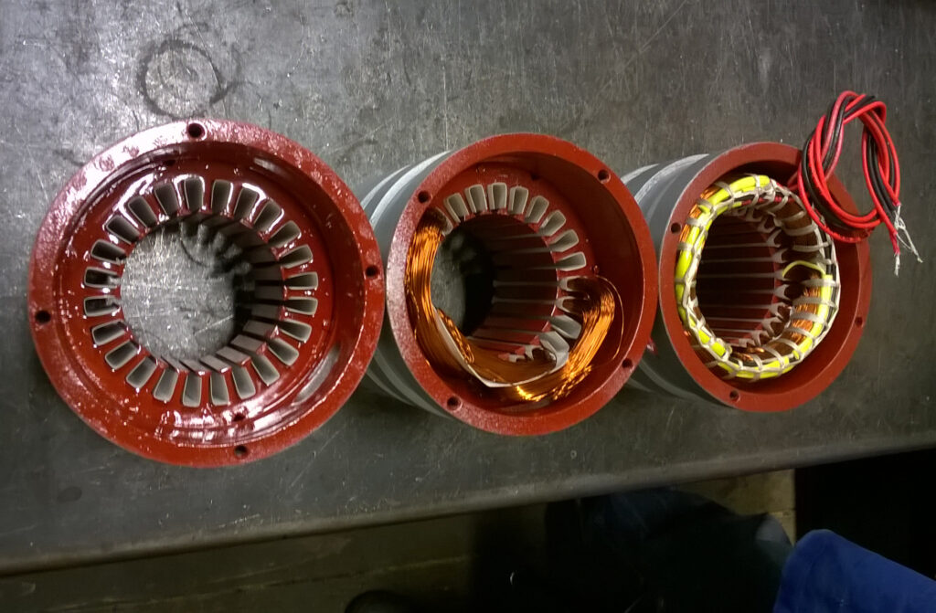 Rewound electric motor stators at different stages of the winding process